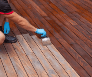 Professional worker staining a deck at Ponderosa Painting.