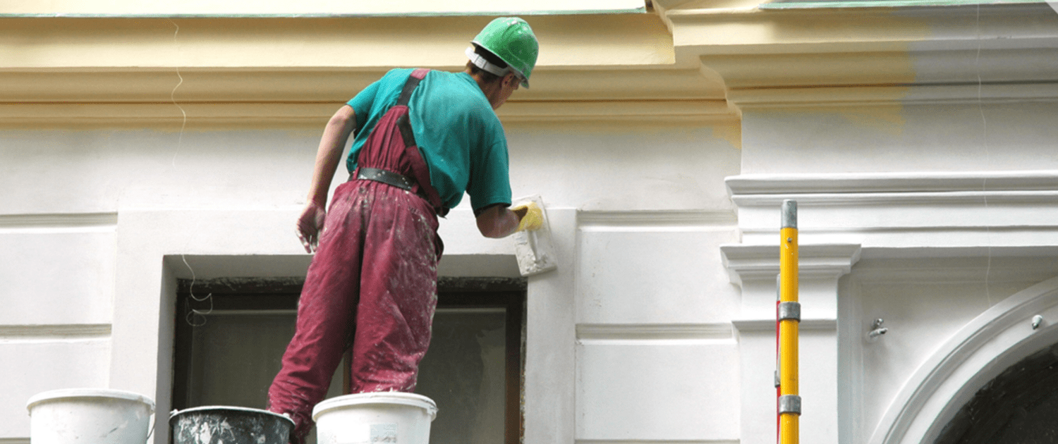 Professional painter painting the exterior of a building.